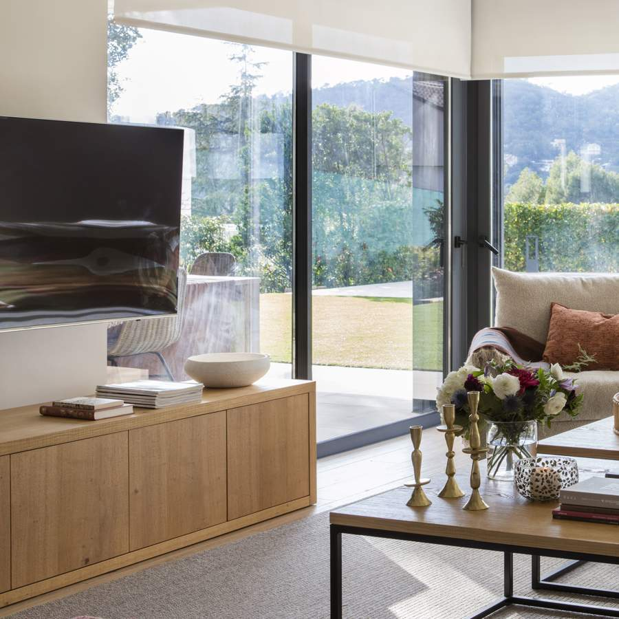 Salón moderno sofá gris estores mueble tv madera